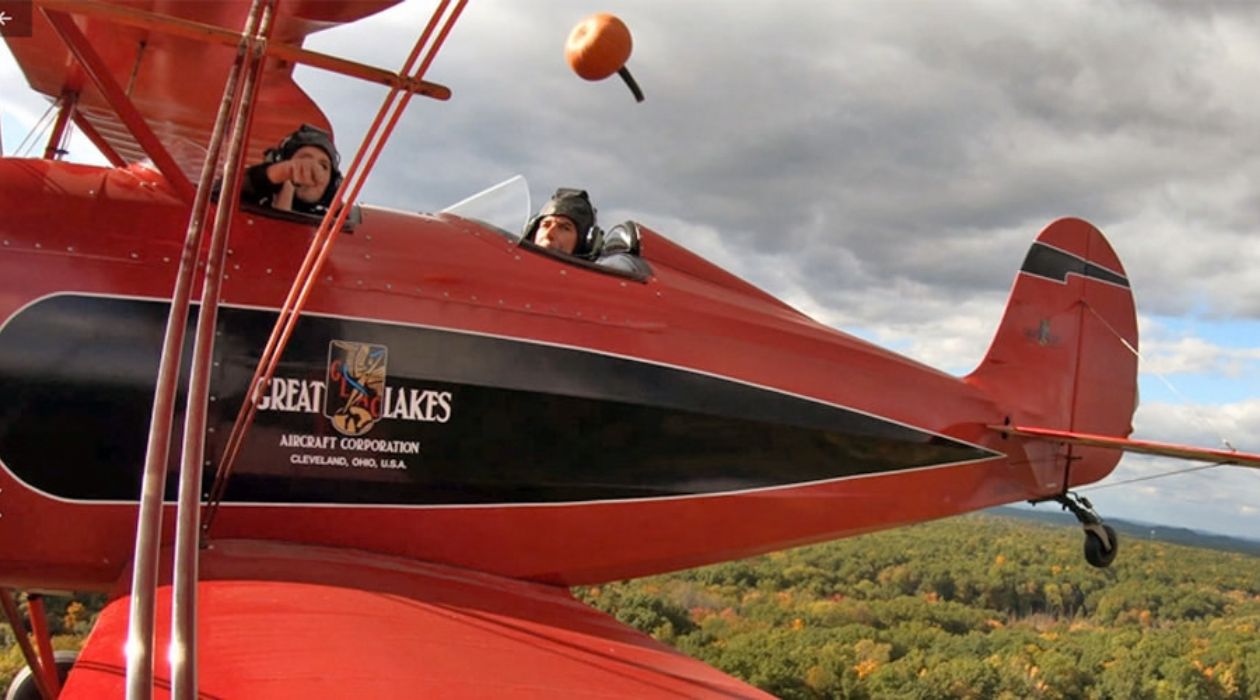 Pumpkins being tossed out of a vintage airplane at the Old Rhinebeck Aerodrome in Red Hook