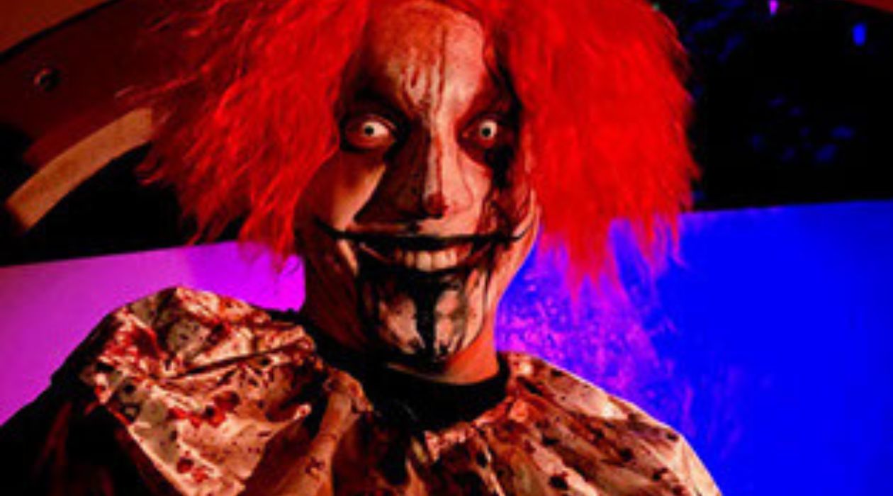 A scary, blood splattered clown with crazy red hair, bulging eyes and a sinister grin at Kevin McCurdy Haunted Mansion, Bowdoin Park, Wappingers Falls