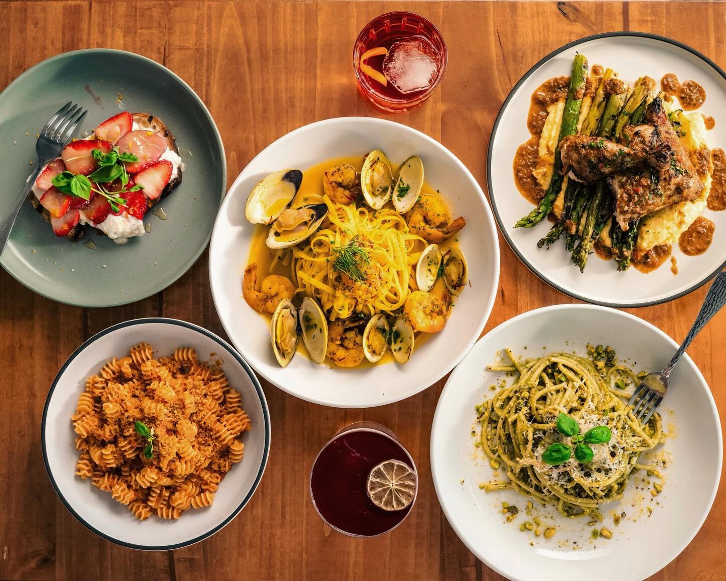 Elaborate spread of Italian dishes including clam pasta, trennete al pesto and a roasted poultry over polenta at Spettro Poughkeepsie