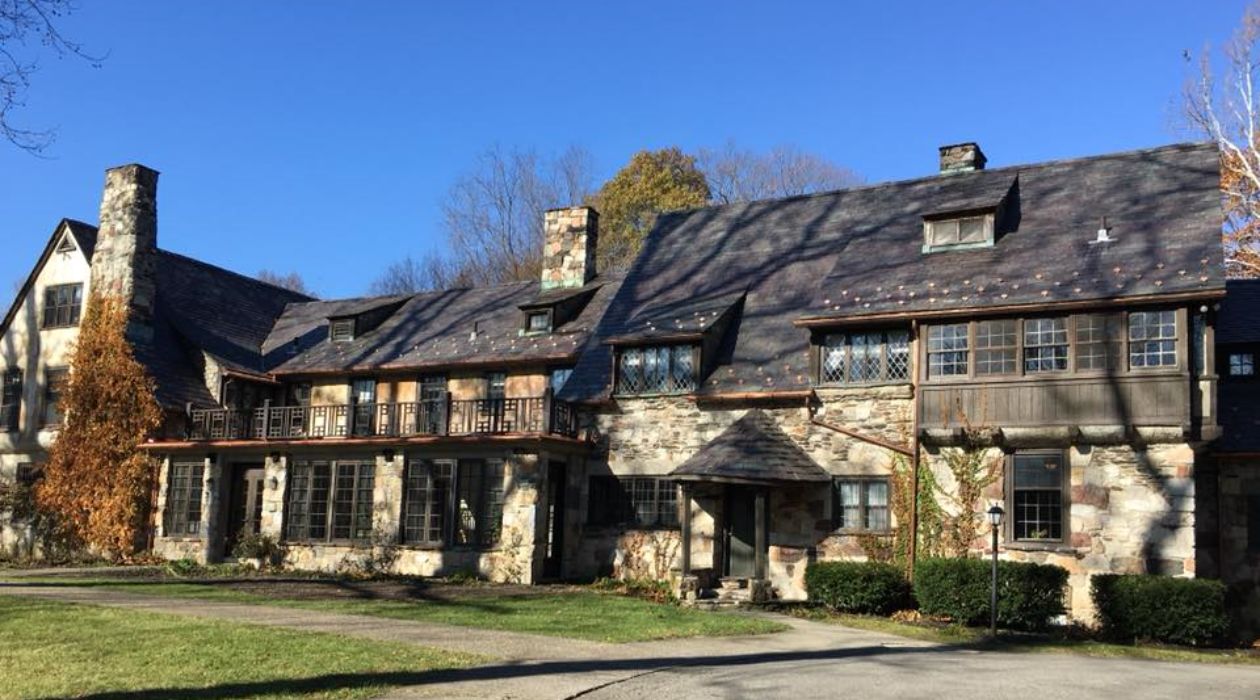 The two story stone exterior of Troutbeck in Amenia with its cascading rooftops.